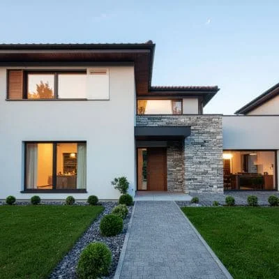 Front yard with paver walkway, lawn, and boxwood landscaping at modern home